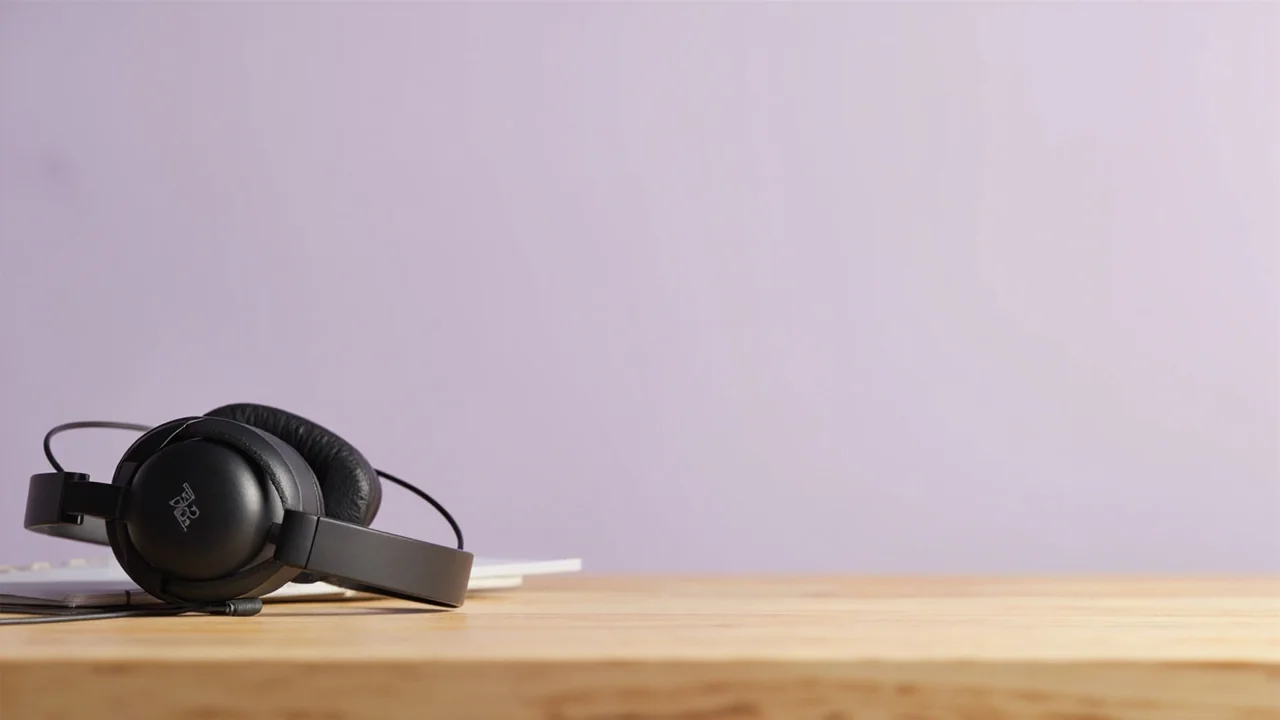 A support agent wearing a headset at a desk with a tablet showing a customer conversation
